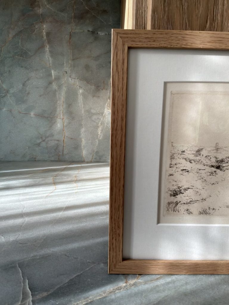 Ingelijste tekening tegen een marmeren wand